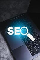 Search Engine Optimization concept. Laptop with SEO lettering. Use technology for search information. Marketing ranking traffic website. photo