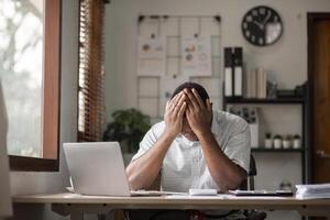 Stressed Male Office Worker Struggling with Deadlines and Workload in a Modern Office Environment photo