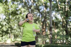 Woman Jogging in a Lush Garden Setting, Embracing Fitness and Nature in a Serene Outdoor Environment photo