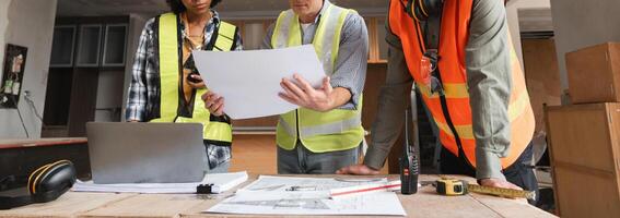 Engineering Team Plans Construction Work with Blueprints and Digital Tools in Modern Workspace photo