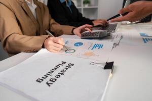 Business Team Collaborating on Strategic Planning and Analyzing Work Plans in a Modern Office Environment photo