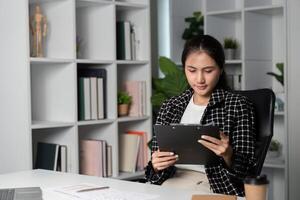 Dedicated Businesswoman Working Late Hours in Modern Office with Technology and Documents photo