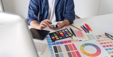 Graphic Designer Selecting Color Pairs on Computer for Creative Design Projects in Modern Workspace with Color Swatches and Digital Tools photo