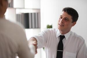 Close-up Businessman shaking hands with colleague in office, concept of agreement and partnership photo
