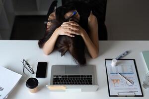 Stressed Office Worker Overwhelmed with Workload at Desk in Modern Corporate Environment photo