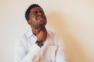 Portrait of young businessman who is having pain in his neck glands. Copy space on image for your text or advert. photo