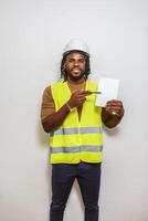 Construction worker highlights safety procedures while standing against a plain wall indoors photo