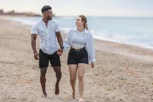 Couple walking hand in hand along the sandy beach of Zapillo in Almeria, Spain, enjoying a beautiful day together photo