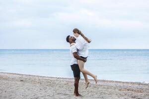 A couple walks along Zapillo beach in Almeria, Spain, sharing joyful moments on a cloudy day photo