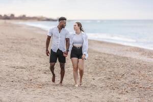 A couple walks hand in hand along the serene beach of Zapillo in Almeria, Spain, enjoying a peaceful moment by the sea photo