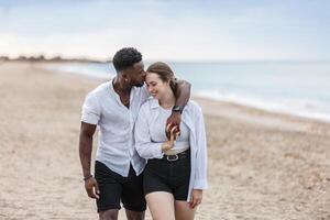 A couple enjoying a romantic walk along the serene beach of Zapillo in Almeria, Spain during a calm evening photo