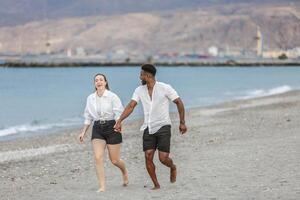 Happy couple walking hand in hand along Playa del Zapillo's sandy beach in Almeria, Spain on a sunny day photo