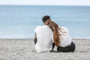 A couple sits on the sand enjoying a moment of serenity at Zapillo Beach in Almeria, Spain, during a sunny afternoon. photo