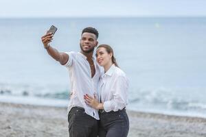 Couple takes a joyful selfie at Playa del Zapillo beach in Almeria, Spain, enjoying a sunny day by the sea photo