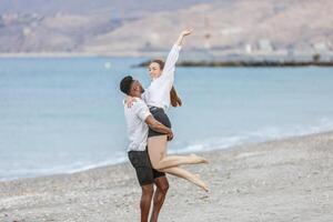 A joyful couple embraces on the sandy shores of Playa del Zapillo, Almeria, Spain during a sunny day by the sea photo