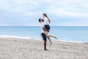 A couple enjoying a joyful walk together on the sandy beach of Zapillo in Almeria, Spain during a cloudy afternoon photo