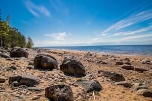 amazing and beatiful sandy beach with small and large stones on a summer day with blue sky in Latvia photo