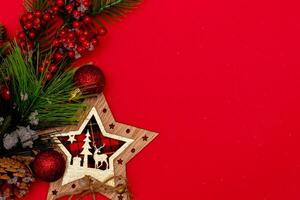 Top view photo christmas spruce branch,christmas star decor on red background for greeting card. Xmas backdrop with space for text.Copyspace.