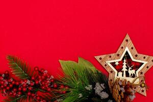 Top view photo christmas spruce branch,christmas star decor on red background for greeting card. Xmas backdrop with space for text.Copyspace.