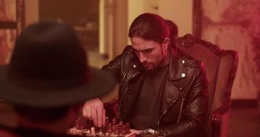 Focused man playing chess with anonymous opponent video