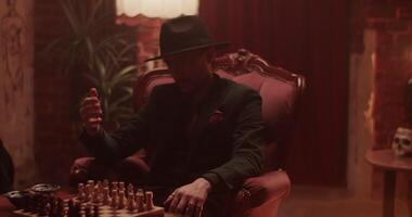 Ethnic man in hat inviting for playing chess video