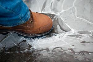 men leg in shoe crushing thin ice photo
