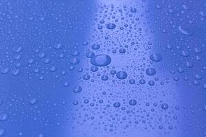 Water drops on bright blue background photo