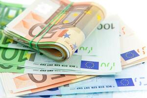 rolled with rubber euro notes on white background photo