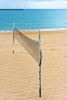 Volleyball net on a sand beach by the sea photo