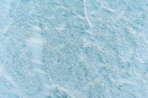 Background frozen water with fancy patterns. Ice texture. Cracks and bubbles inside frozen water. photo