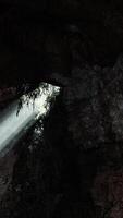 Sunlight streaming into a mysterious cave, creating a volume of light video
