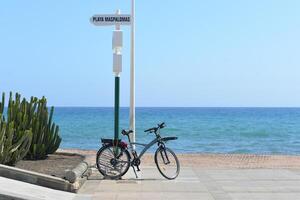 Bicycle parked on the promenade at the background of the sea in Maspalomas, Gran Canaria, Canary Islands, Spain photo