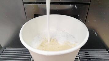 Baristastyle coffee preparation brewing process of steaming frothy espresso flowing into a white cup. video