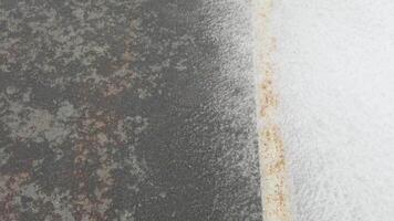 Dynamic waves crashing over rusty pier surface in highresolution slow motion, capturing nature's power and texture in detailed closeup sequence. video