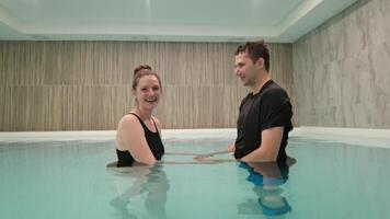 Couple engages in relaxing hydrotherapy session in modern spa pool environment. video