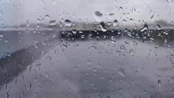 Raindrops transform scenic landscape through blurred wet glass in motion. video