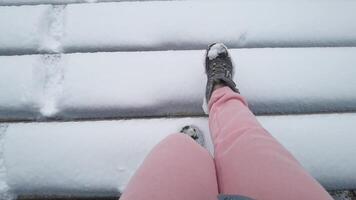Walking on snowcovered wooden bridge cozy winter stroll in pink pants captured from a firstperson perspective on a cold, frosty day. video
