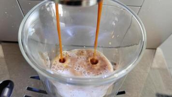 Closeup of espresso pouring into glass, capturing rich aroma and creamy texture in slow motion. video