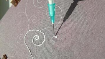 Intricate textile embroidery process with precision needlework and artistic floral patterns under sunlight. video