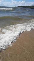 Relaxing coastal waves gently lapping on sandy beach with barefoot view. video