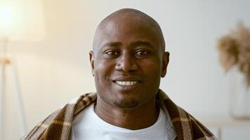 African American man in his 30s is adjusting his face mask in a cozy home setting. The atmosphere is calm and emphasizes personal safety during challenging times. video