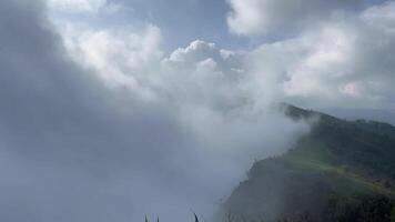Mist flows on the mountain, Time lapse of a breathtaking mountain landscape covered in rolling mist under a bright blue sky with scattered clouds. Perfect for nature, travel, and relaxation themes video