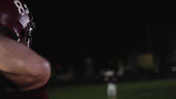 An American football player practicing throwing and catching the ball on a field video