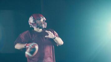 An American football player practicing throwing and catching the ball on a field video