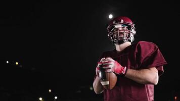 An American football player practicing throwing and catching the ball on a field video