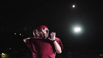 An American football player practicing throwing and catching the ball on a field video