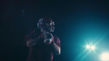 An American football player practicing throwing and catching the ball on a field video