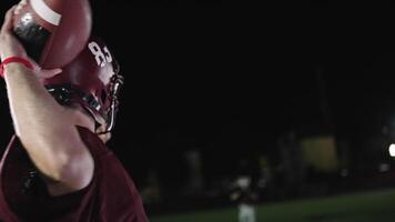 An American football player practicing throwing and catching the ball on a field video