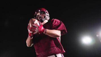 An American football player practicing throwing and catching the ball on a field video