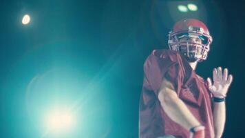 An American football player practicing throwing and catching the ball on a field video